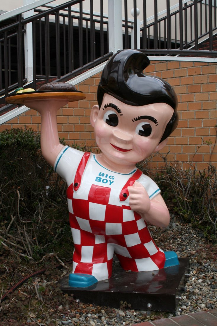 A Big Boy statue in red-checked overalls holding a plate aloft.
