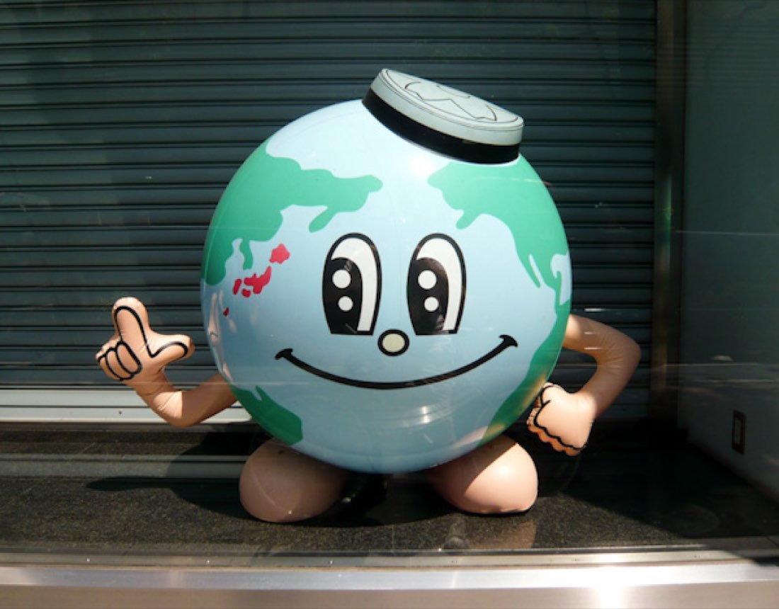 An inflatable globe with a smiling face and a ring-pull on top, shaped like a drinks can, giving a thumbs up.