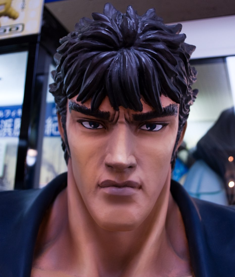 A life-size statue of Kenshirō from Fist of the North Star, staring straight ahead in a shop window.