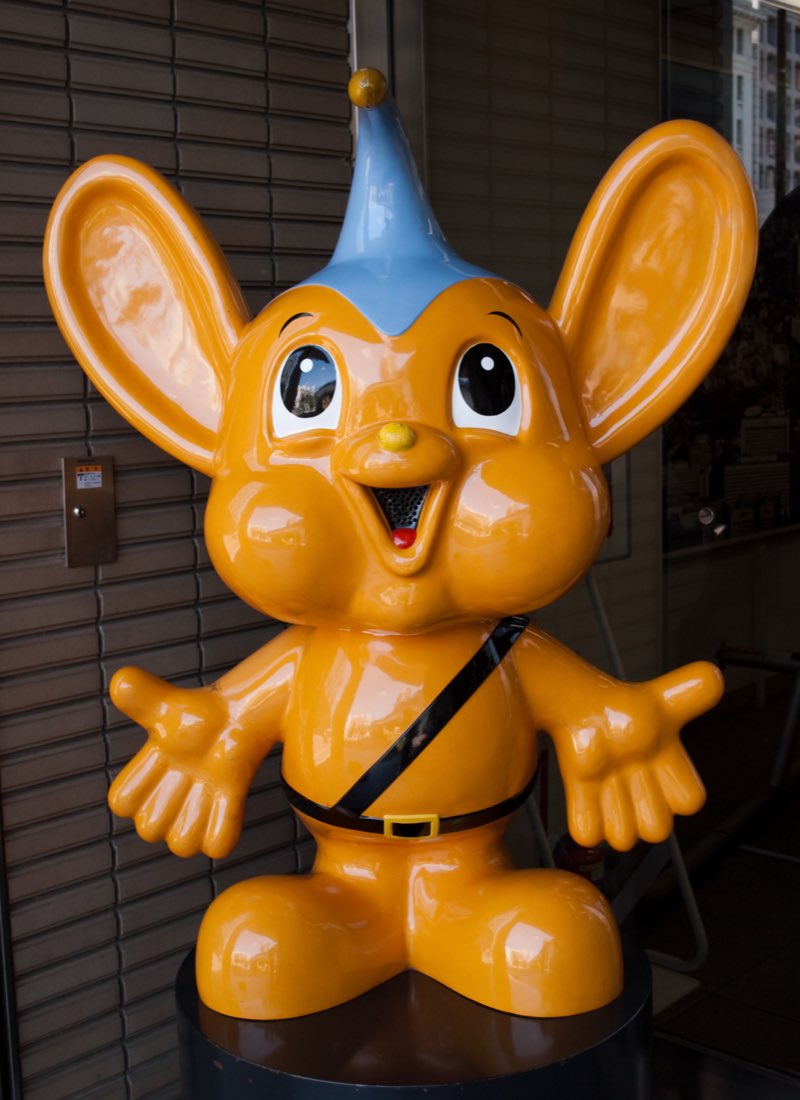 Pipo-kun, the orange Tokyo police mascot with big ears and an antenna on his head, arms open.