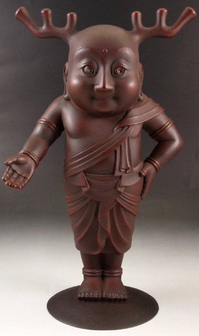 A bronze statue of Sentō-kun, a young Buddha figure with deer antlers, on a plinth.